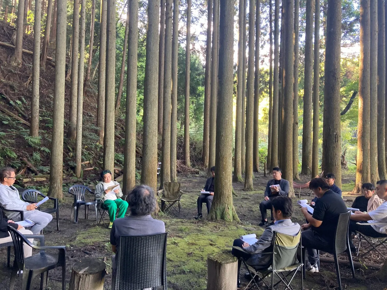 杉林の中で輪になって行うミーティング